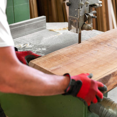 mężczyzna tnie drewno za pomocą piły taśmowej, którą trzeba regenerować